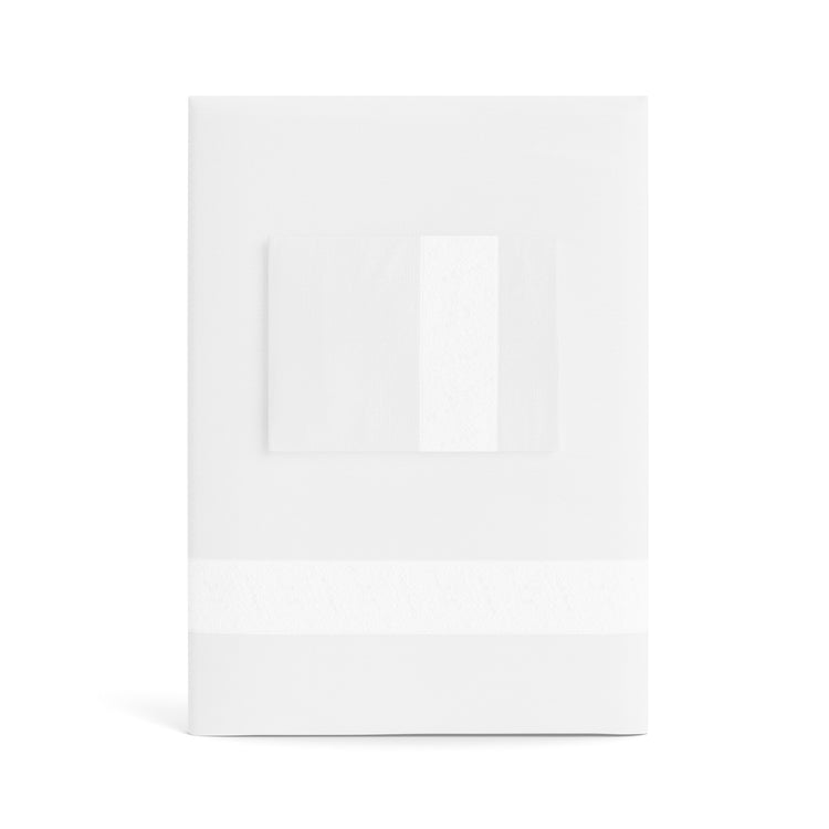 A folded white Minaudiere Sheet Set by Judith Leiber Couture x Ann Gish, shown with its matching pillowcase on top, featuring a bone-colored sequenced border band that mirrors the jeweled sparkle of the Minaudiere design. - SSMIK-WHI-BON SSMIQ-WHI-BON