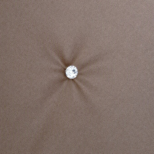 A single round clear crystal or gemstone stud with a silver-toned setting, centered on a soft, metallic fabric background. Swatch of Monaco Crystal in Metal - COMOK-MET-SIL COMOQ-MET-SIL THMOK-MET-SIL